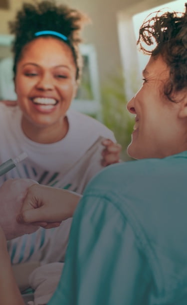 An IQOS device held by one person and a smartphone held by another person.